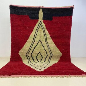 a large, colorful rug with a geometric design in red, black, and yellow.