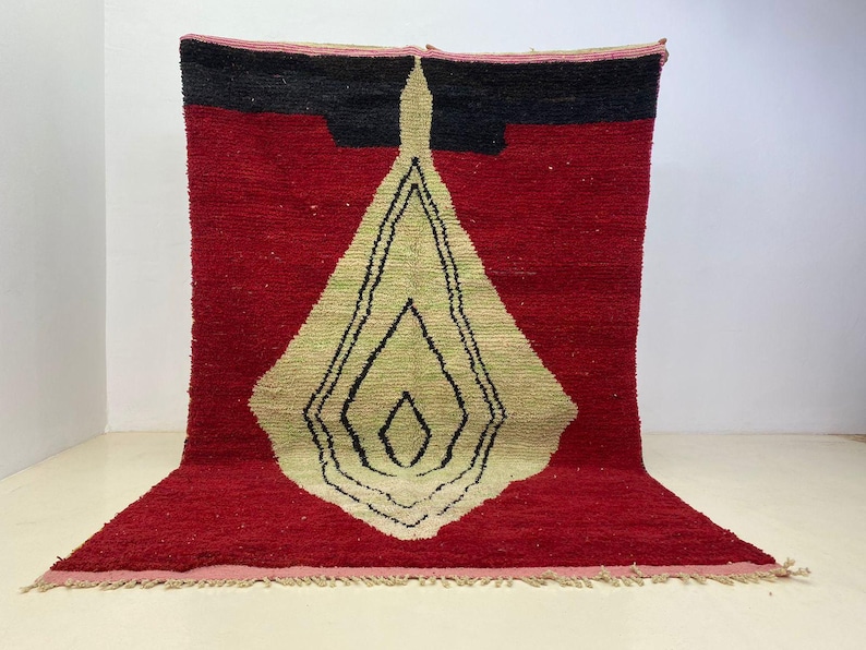 a large, colorful rug with a geometric design in red, black, and yellow.