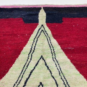 a vibrant, colorful rug with a striking geometric pattern in red, black, and white.