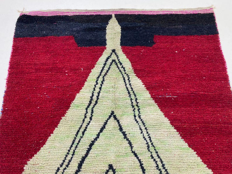 a vibrant, colorful rug with a striking geometric pattern in red, black, and white.