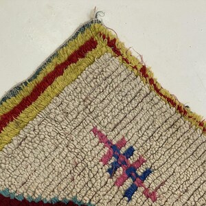 a close-up view of a colorful, textured rug with a geometric pattern.