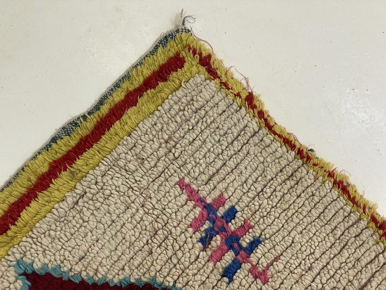 a close-up view of a colorful, textured rug with a geometric pattern.