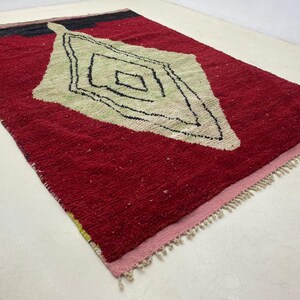 a red and white rug with a geometric design on it.