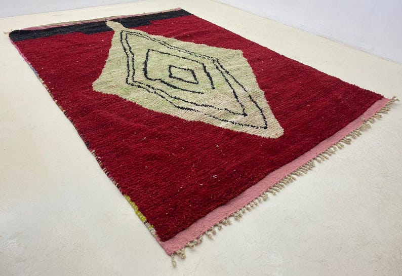 a red and white rug with a geometric design on it.