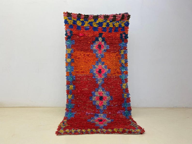 A vibrant, colorful rug with a geometric pattern of red, orange, yellow, and blue hues.