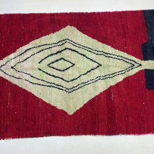 a vibrant red and white rug with a geometric pattern in black and white.