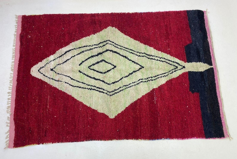 a vibrant red and white rug with a geometric pattern in black and white.
