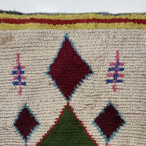 a colorful, intricately designed rug with a diamond pattern and various geometric shapes.