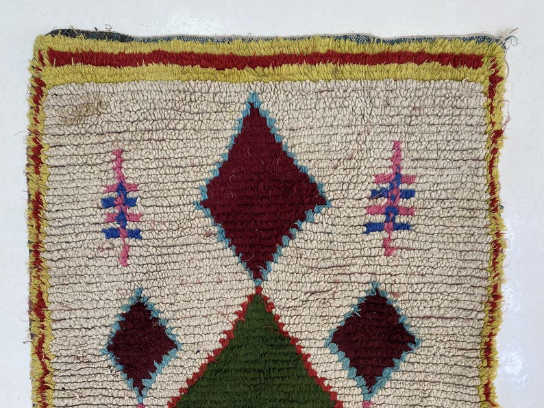 a colorful, intricately designed rug with a diamond pattern and various geometric shapes.