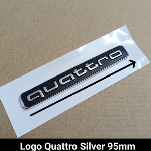 Könnte beinhalten: Silbernes "quattro" Logo mit schwarzem Hintergrund. Das Logo ist 95 mm lang.