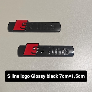 Può includere: Due emblemi per auto S line neri lucidi con dettagli rossi. Ogni emblema è rettangolare, misura circa 7 cm di lunghezza e 1,5 cm di altezza. Il testo "S line" è visibile su ogni emblema.