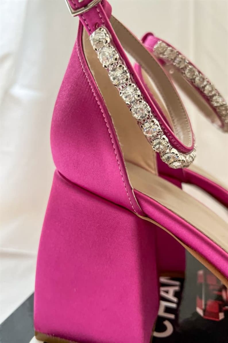 May include: Pink satin heeled sandals with a crystal embellished ankle strap.