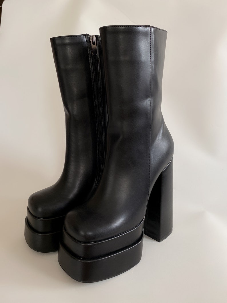 May include: Black platform boots with a chunky heel and a zip on the side.