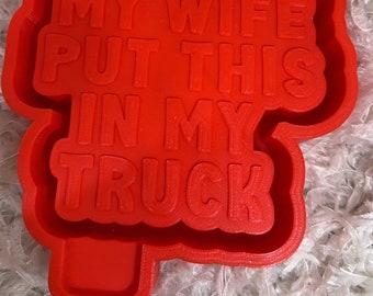 May include: Red plastic mold for making a cookie or cake topper with the text "My wife put this in my truck".