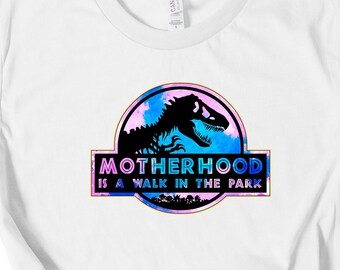 May include: White t-shirt with a blue and pink graphic of a dinosaur with the text "MOTHERHOOD IS A WALK IN THE PARK"