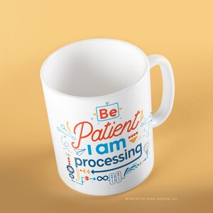 Puede incluir: Taza de cerámica blanca con un diseño azul, naranja y rojo que dice "Sé paciente, estoy procesando".