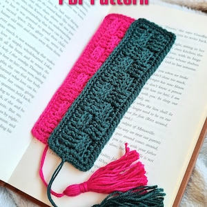 May include: Two crocheted bookmarks with tassels. One bookmark is dark green and the other is hot pink. The bookmarks are laying on a book with the text "PDF Pattern" visible.