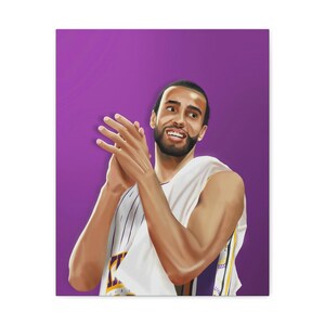 May include: Canvas art print of a basketball player in a white and purple jersey, clapping. The artwork features a purple background and a detailed portrait of the athlete. The jersey has a gold and purple design.