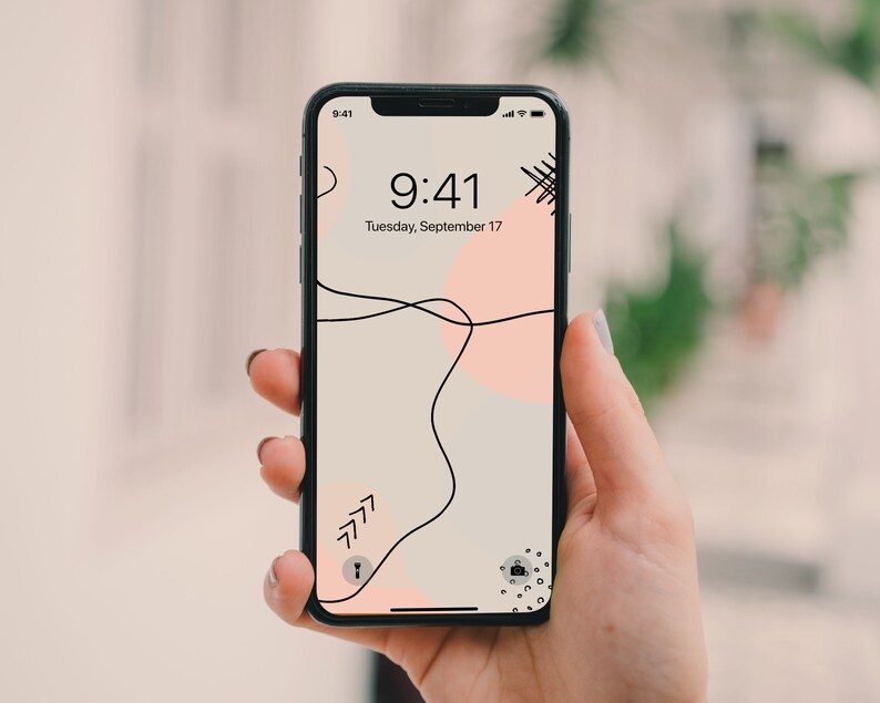 May include: A black smartphone with a white and pink abstract design wallpaper. The time is 9:41 and the date is Tuesday, September 17.
