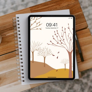 Può includere: Un tablet digitale che mostra uno sfondo minimalista autunnale con alberi marroni e foglie su uno sfondo bianco. L'ora è 09:41 e la data è martedì 17 settembre.