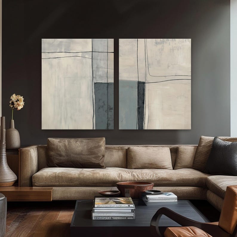 Peut inclure: Deux peintures abstraites aux tons neutres et aux d&eacute;tails de lignes noires sont accroch&eacute;es au-dessus d'un canap&eacute; marron. L'&oelig;uvre pr&eacute;sente des formes rectangulaires dans des tons de blanc, de gris et de bleu. Le salon comprend une table basse et des vases d&eacute;coratifs.