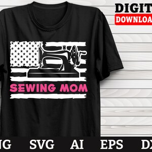Puede incluir: Una camiseta negra con un diseño de bandera estadounidense blanca que presenta una máquina de coser y el texto "Sewing Mom" en rosa.