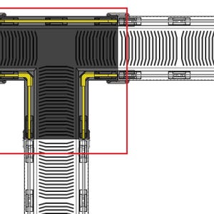 May include: Top-down view of a mechanical component with a T-shaped design. The component is primarily black with yellow and silver accents. The design features a series of parallel lines and rectangular shapes, suggesting a complex internal structure.