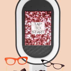 May include: A white photo booth with a black screen displaying a pink sparkly background with the text "TAP TO START".  There are several props in front of the booth, including a pair of red glasses, a black bow tie, a black mustache, and two red lips.