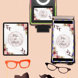 May include: A photo booth with a white ring light and a screen displaying "Tap to Start" in a floral design. The photo booth is surrounded by props including glasses, a bow tie, a mustache, and two lips.