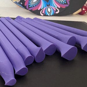 Peut inclure: Un ensemble de 13 aiguilles à tricoter violettes avec des pointes pointues. Les aiguilles sont disposées en rangée, les pointes pointant vers la droite.