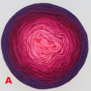 Può includere: Un gomitolo di filato in un gradiente di rosa, viola e magenta. Il filato è avvolto a forma di palla.