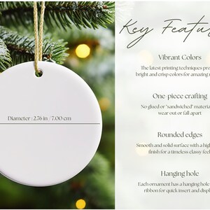 May include: A white, circular Christmas ornament, 7.00 cm in diameter and 3 mm thick, with a hanging hole and gold string. The text "Key Features" is visible. The ornament is displayed against a backdrop of evergreen branches.