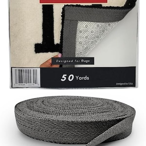 May include: A roll of 50 yards of black twill tape, 1.5 inches wide, made of 70% cotton and 30% polyester. The tape is designed for rugs and is made in the USA. The label reads "DABLINE Twill Tape Designed for Rugs 50 Yards Designed in USA".