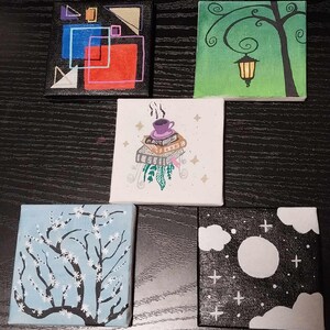 May include: Five small canvas paintings with different designs. The first painting is black with geometric shapes in red, blue, and yellow. The second painting is green with a tree and a lamp. The third painting is white with a cup of coffee on top of a stack of books. The fourth painting is blue with a white tree with white flowers. The fifth painting is black with a white moon and clouds.