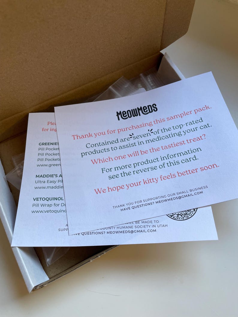May include: A cardboard box containing a sampler pack of cat medication products. The pack includes a card with the text "MeowMeds" and information about the products. The card also includes the text "We hope your kitty feels better soon."