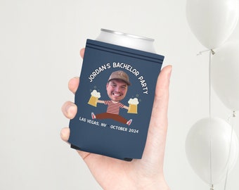 May include: A blue can cooler with a cartoon illustration of a person holding two beers. The text on the cooler reads "Jordan's Bachelor Party Las Vegas, NV October 2024".
