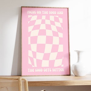 May include: Pink and white checkered design with the text "Focus on the good and the good gets better" in a pink frame.