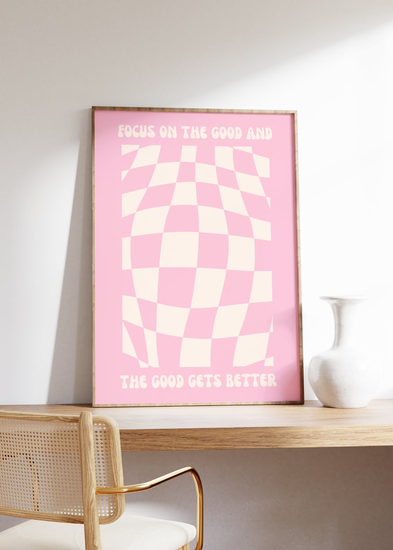 May include: Pink and white checkered design with the text "Focus on the good and the good gets better" in a pink frame.