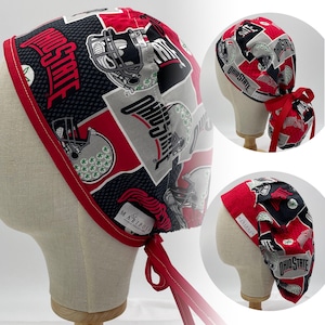 Peut inclure: Un bonnet de chirurgien à motifs rouges, noirs et gris, avec les mots "Ohio State" et des graphiques de casques de football. Le bonnet a une bordure et des liens rouges, et est présenté sur une tête de mannequin. La marque "Mariposa" est visible.
