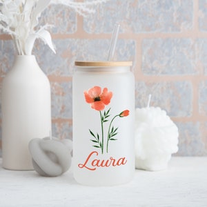 May include: A frosted glass tumbler with a bamboo lid and a clear straw. The tumbler features a watercolour poppy design in shades of orange and green, with the name "Laura" in orange script. The tumbler is part of a drinkware collection.