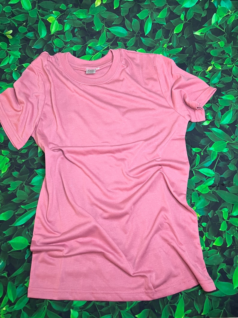 Op de afbeelding: Een effen, lichtroze T-shirt met korte mouwen en een ronde hals.