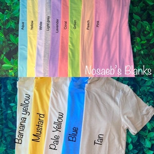 May include: A variety of blank t-shirts in different colors, including aqua, yellow, white, light grey, lavender, coral, green, peach, pink, banana yellow, mustard, pale yellow, blue, and tan. The text "Nosaeb's Blanks" is visible in the image.