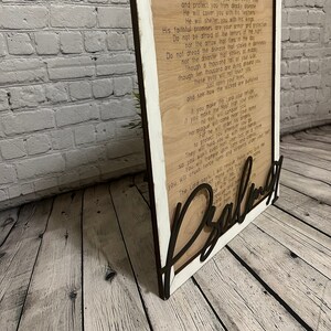 A rectangular white frame with the words from Psalm 91 laser etched onto the wood background. The words "Pslam91" is cut out in script letters and glued over the frame.