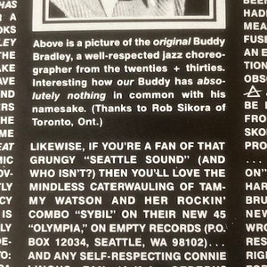 Pu&ograve; includere: Foto in bianco e nero di un uomo in abito e cravatta. Il testo recita "Above is a picture of the original Buddy Bradley, a well-respected jazz choreographer from the twenties + thirties. Interesting how our Buddy has absolutely nothing in common with his namesake. (Thanks to Rob Sikora of Toronto, Ont.) Likewise, if you're a fan of that grungy "Seattle Sound" (and who isn't?) then you'll love the mindless caterwauling of Tammy Watson and her rockin' combo "Sybil" on their new 45 "Olympia," on Empty Records (P.O. Box 12034, Seattle, WA 98102)... And any self-respecting Connie Lingus fan (a.k.a. Cerebus reader) ought to know about..."