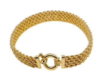 May include: A gold-toned bracelet with a woven chain design and a toggle clasp.
