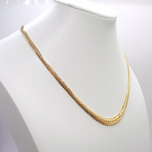 May include: A gold chain necklace with a snake chain design. The chain is on a white display stand.