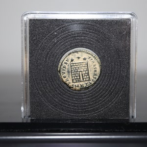 Peut inclure: Une pi&egrave;ce d'argent avec une tour et l'inscription "PROVIDENTIA AVG" d'un c&ocirc;t&eacute; et "S P Q R" de l'autre. La pi&egrave;ce est dans un porte-pi&egrave;ce en plastique.