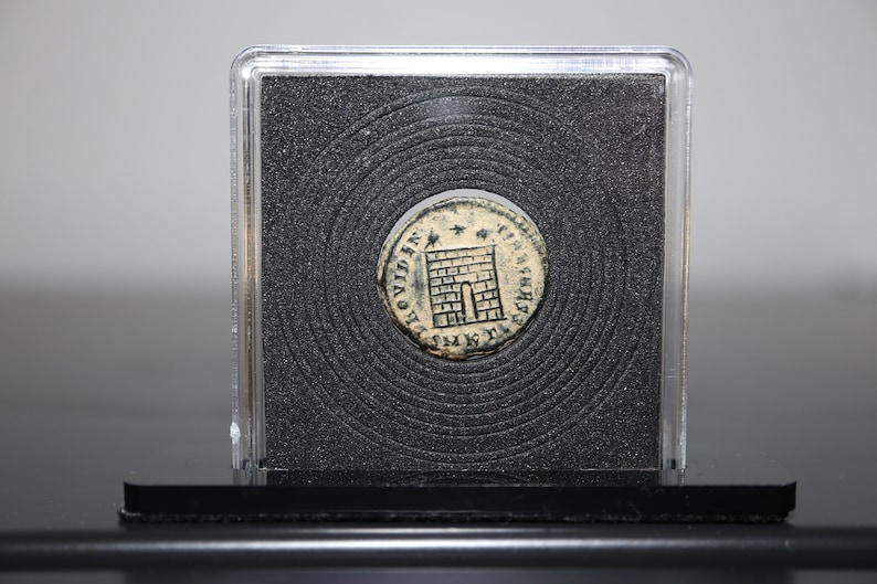 Peut inclure: Une pi&egrave;ce d'argent avec une tour et l'inscription "PROVIDENTIA AVG" d'un c&ocirc;t&eacute; et "S P Q R" de l'autre. La pi&egrave;ce est dans un porte-pi&egrave;ce en plastique.