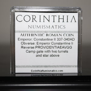Peut inclure: Une carte blanche avec du texte noir dans un bo&icirc;tier en plastique transparent. Le texte indique "CORINTHIA NUMISMATICS AUTHENTIC ROMAN COIN Emperor: Constantine II 337-340AD Obverse: Emperor Constantine II Reverse: PROVIDENTIAEAVGG Camp gate with two turrets and star above CorinthiaNumismatics.com".