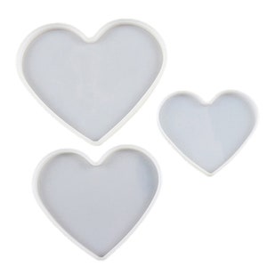 Puede incluir: Tres moldes de silicona en forma de corazón de diferentes tamaños, de color blanco.
